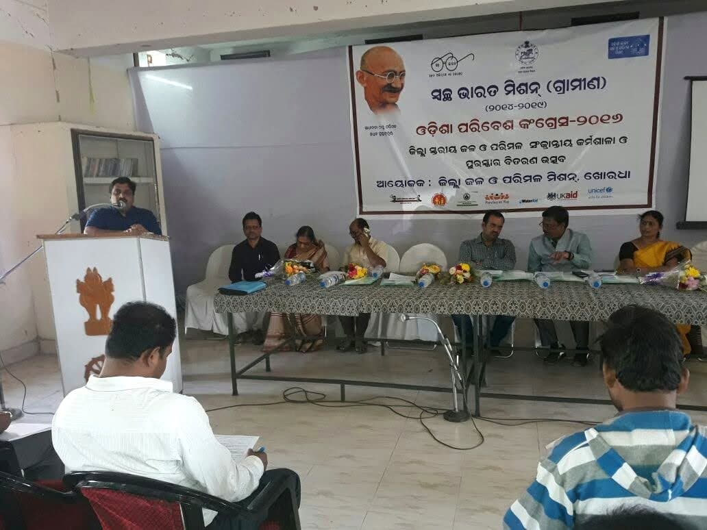 An IIES programme convened on a dais with district government officials