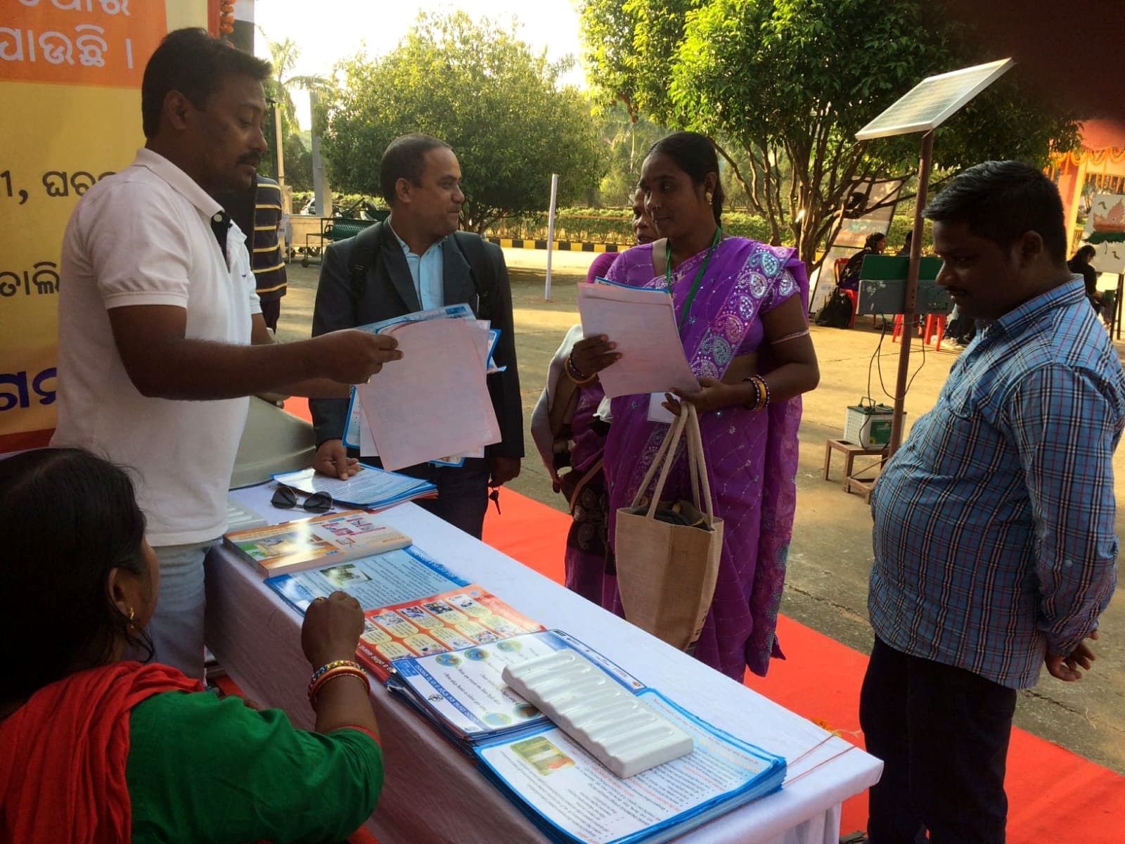 Community members collecting programme material at an IIES outreach desk